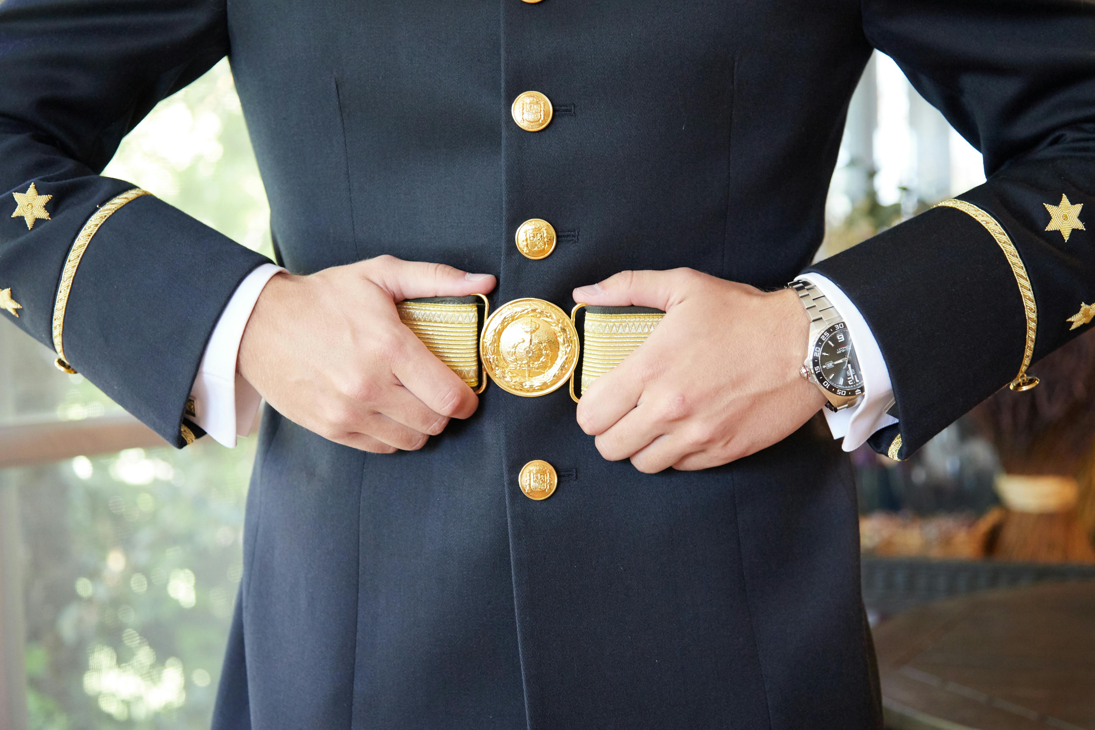 person in blue military uniform with golden belt