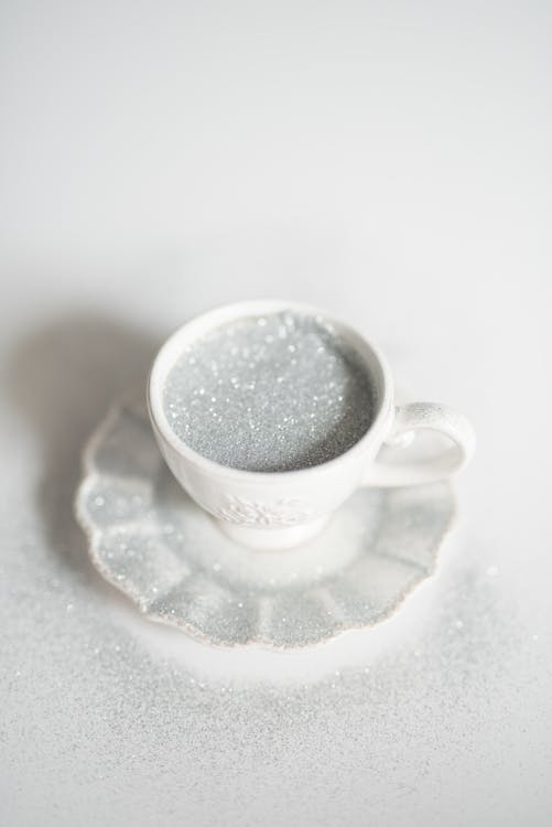 Silver Glitters in a White Ceramic Cup on Saucer