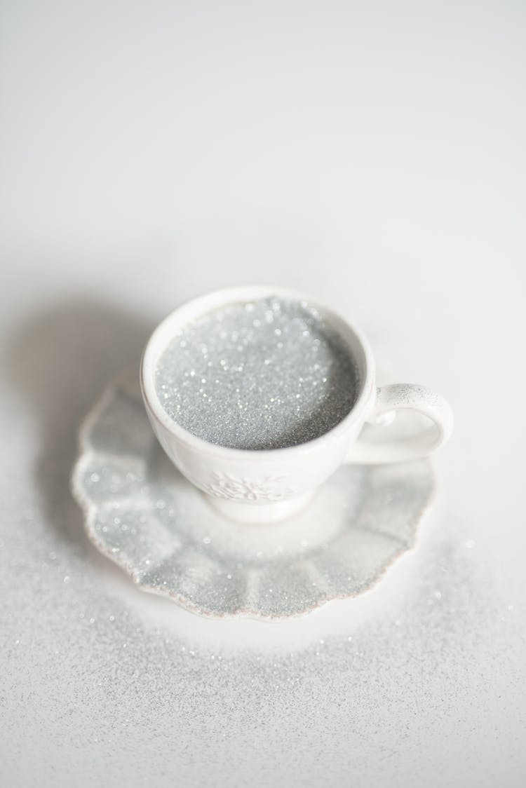 Silver Glitters In A White Ceramic Cup On Saucer