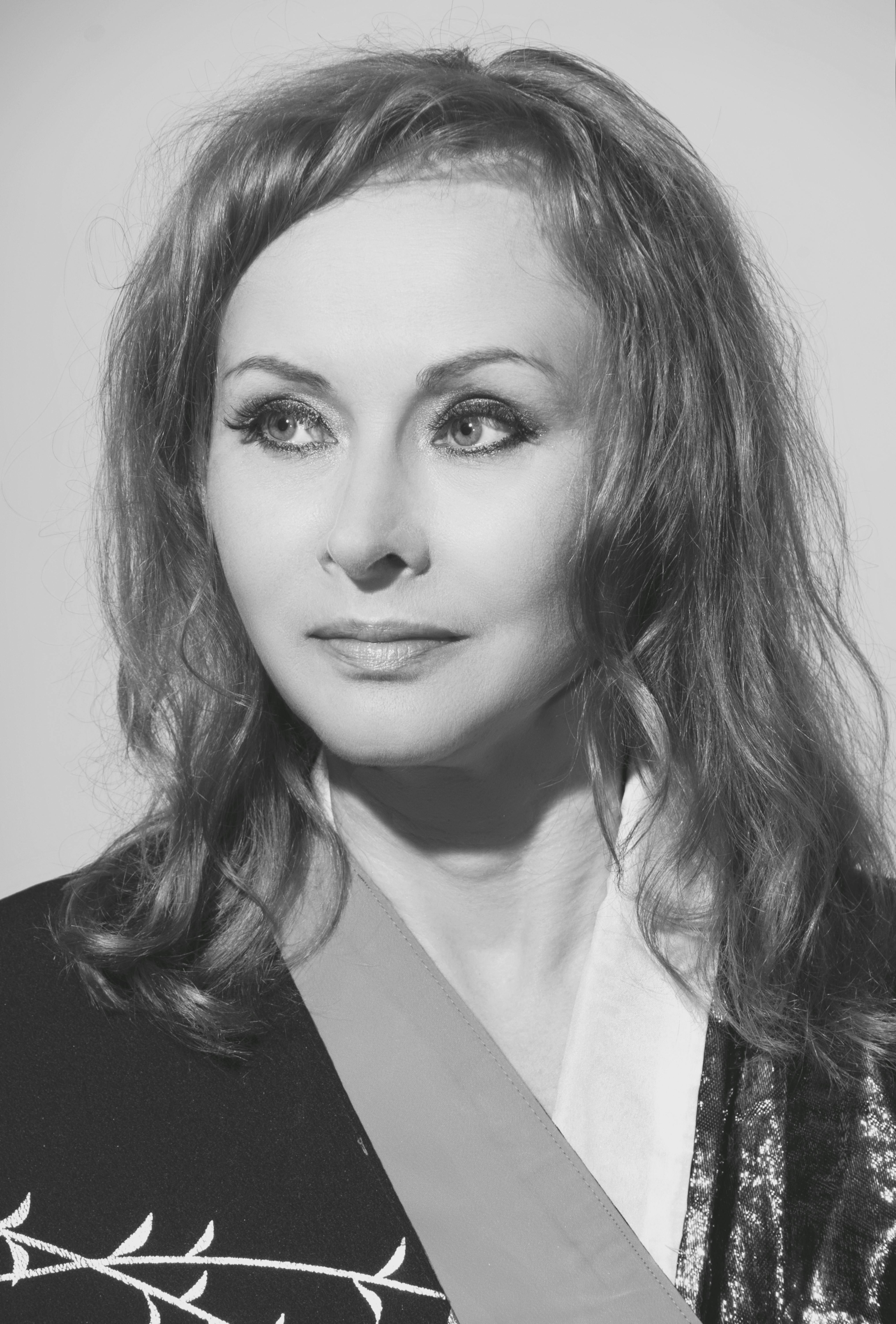 Black-and-white portrait of a woman with vintage style, exuding elegance.
