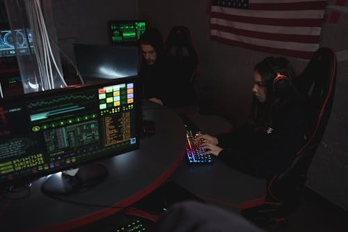 Two People Sitting on Chairs Using Computers