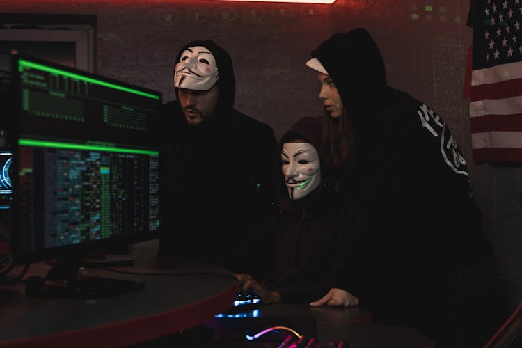 Three People Hacking A Computer System