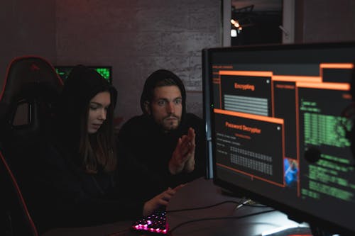 Free Man and Woman Hacking a Computer System Stock Photo