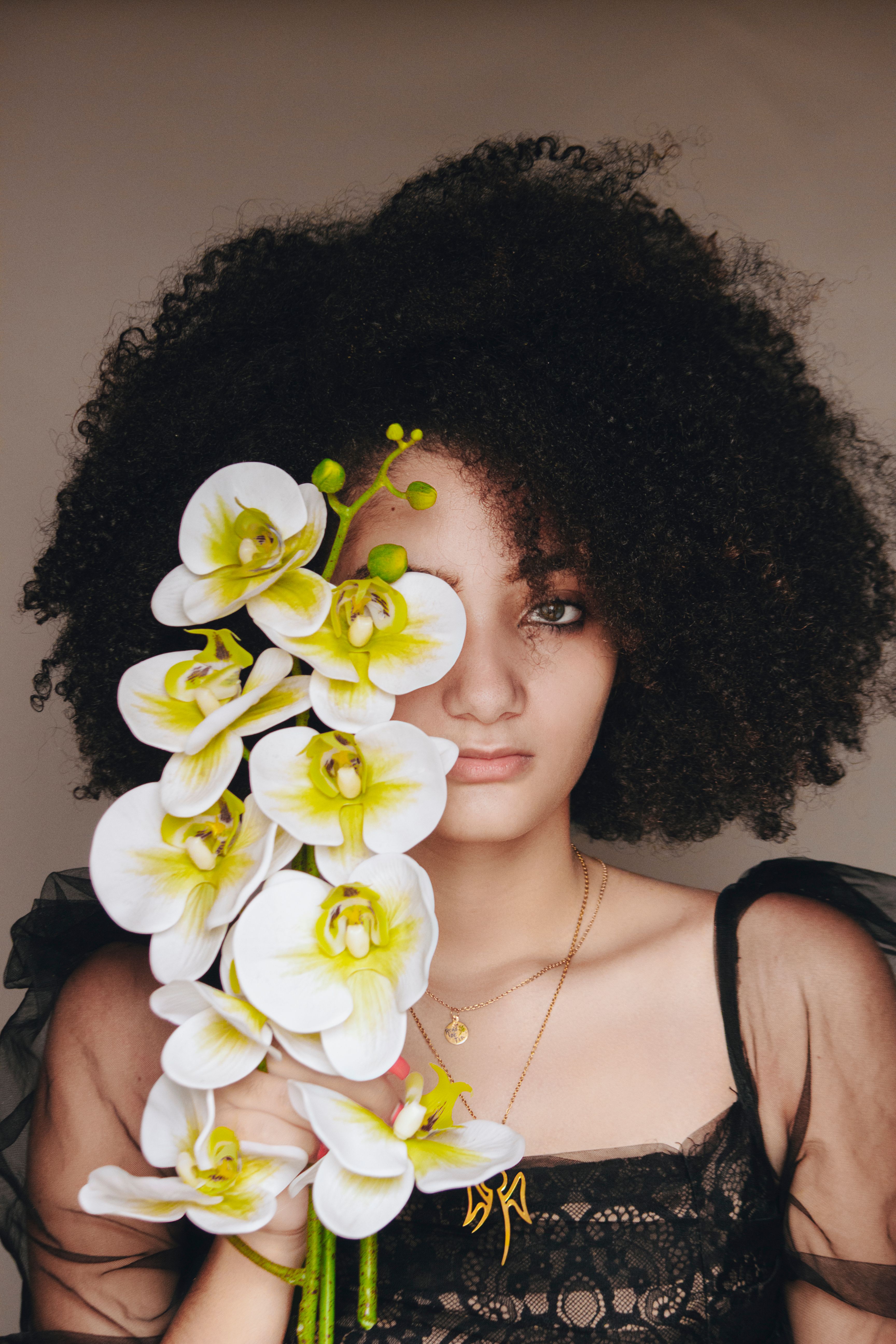 Woman Wearing Black Top while Holding White Flowers · Free Stock Photo
