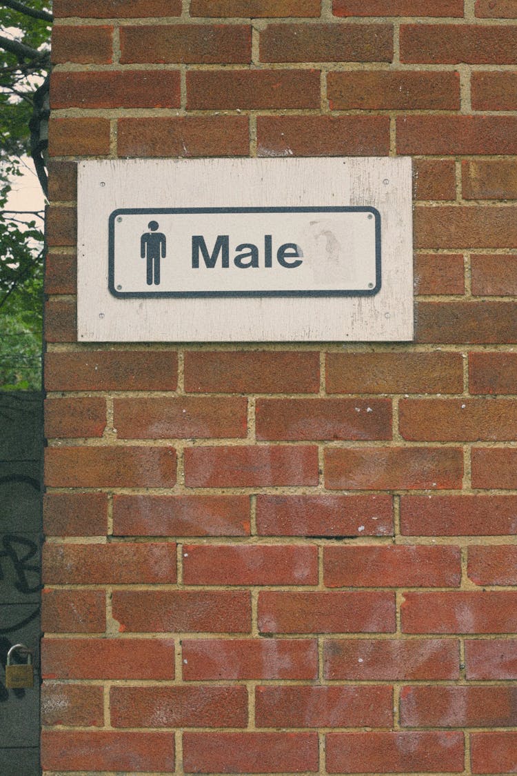 A Male Restroom Sign On Brick Wall