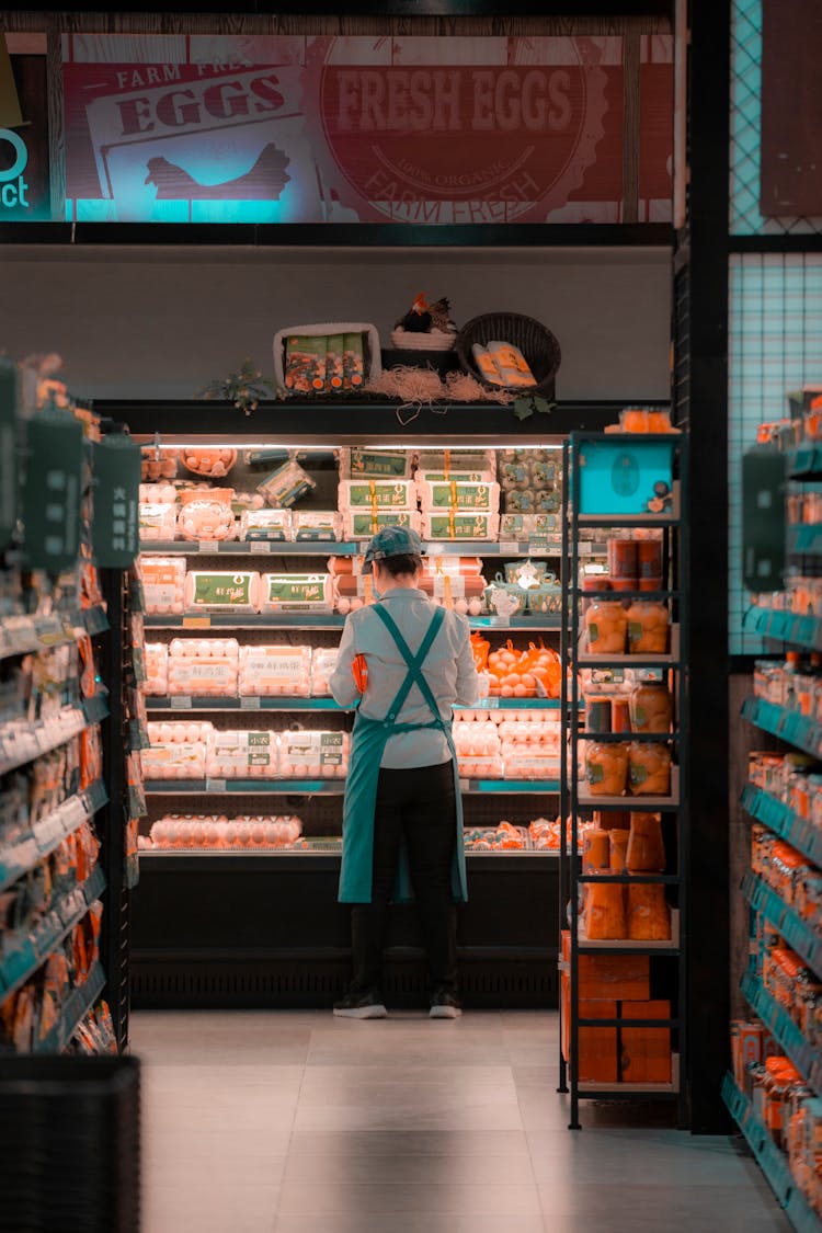 A Woman Employee Of A Supermarket Standing Beside Chilled Products