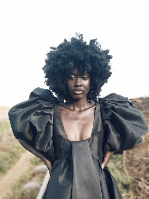 Woman in Black Dress Standing while Looking at Camera