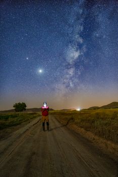 在伊朗的乡村道路上，一个人正仰望星空与银河