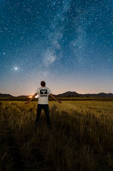 在伊朗萨维，一名男子站在星空下，捕捉银河系