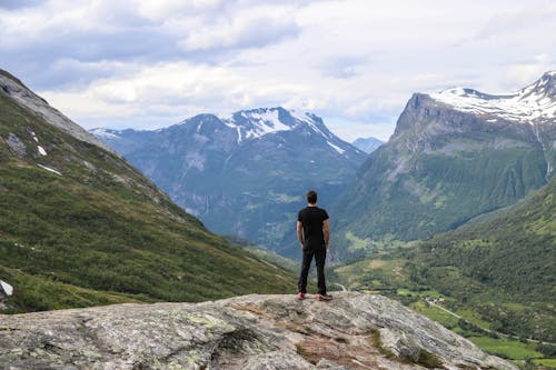 Free Back View of a Man Looking at Sceneries of the Mountains Stock Photo