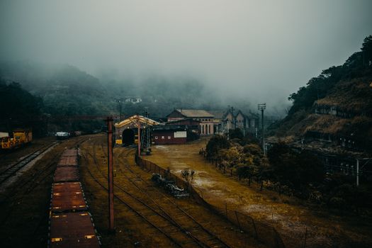 一个雾蒙蒙的早晨，一座废弃火车站被郁郁葱葱的绿化和山丘环绕着