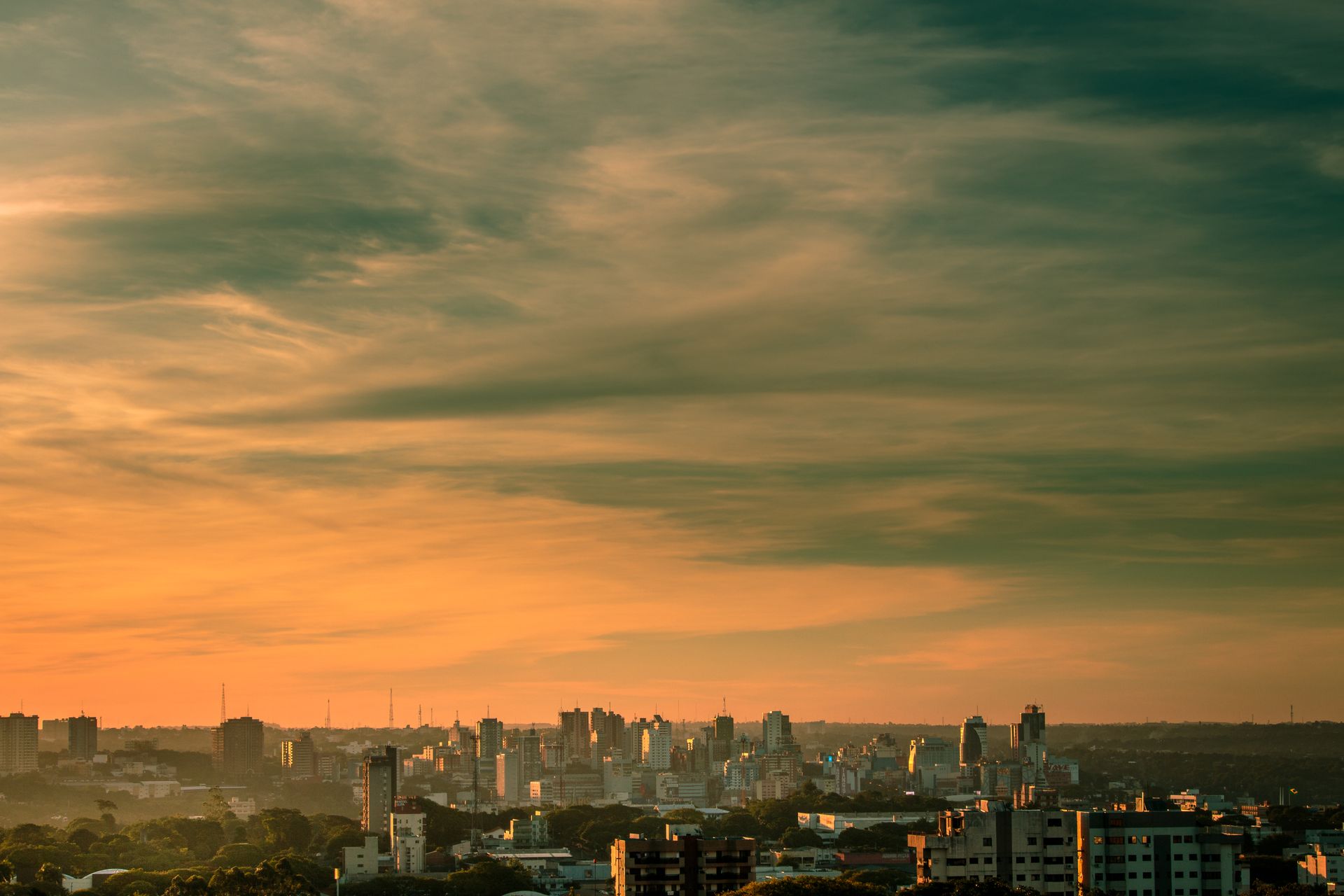 Stunning sunset view of Ciudad del Este skyline with dramatic clouds and vibrant colors.