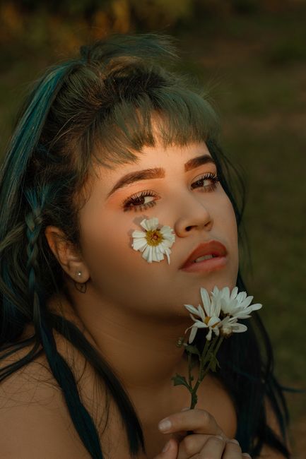 Close-up portrait of a woman with green hair holding a white flower outdoors in Sao Paulo.