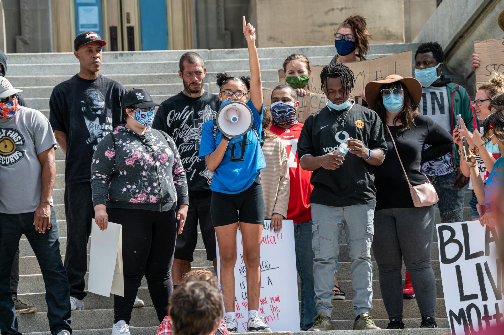 Group of people with masks protesting on street