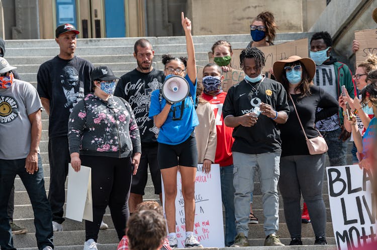 Group Of People With Masks Protesting On Street