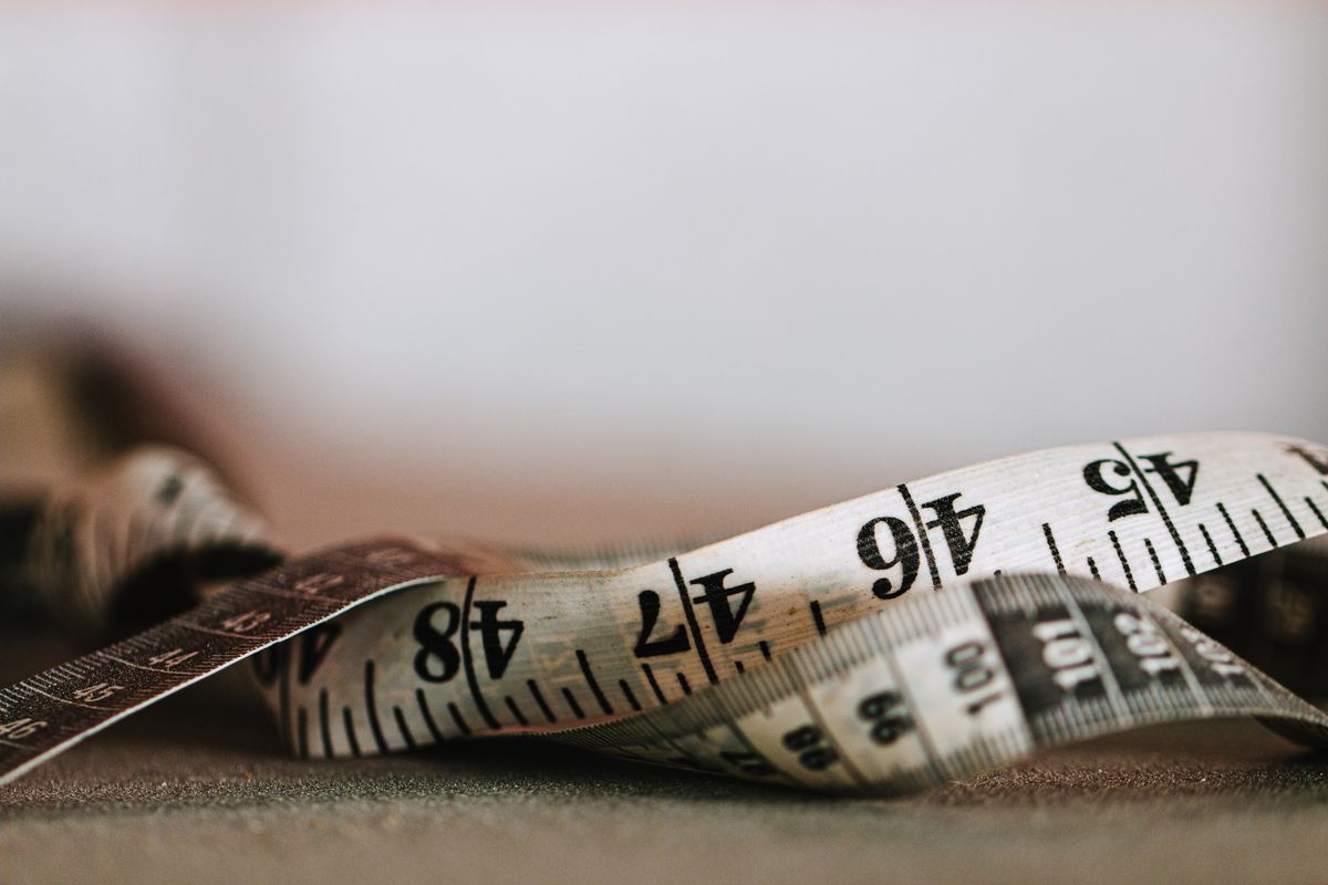 Close-up of a tailor's tape measure showing both inch and centimeter markings