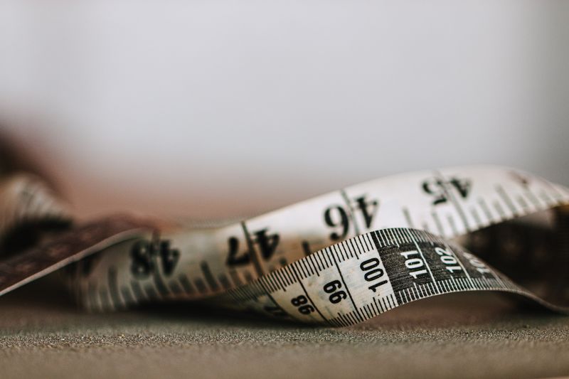 Close-up of a tape measure showing inch and centimeter markings in shallow focus