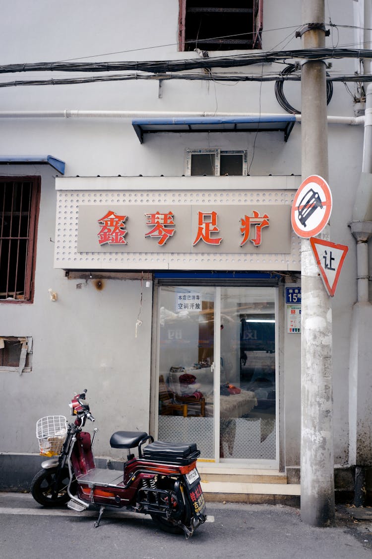 A Scooter Parked Beside An Oriental Store