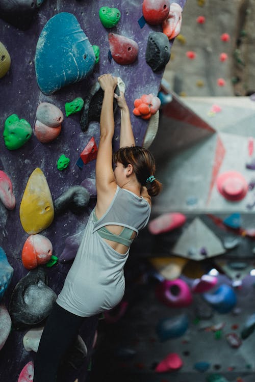 Strong climber hanging on climbing wall