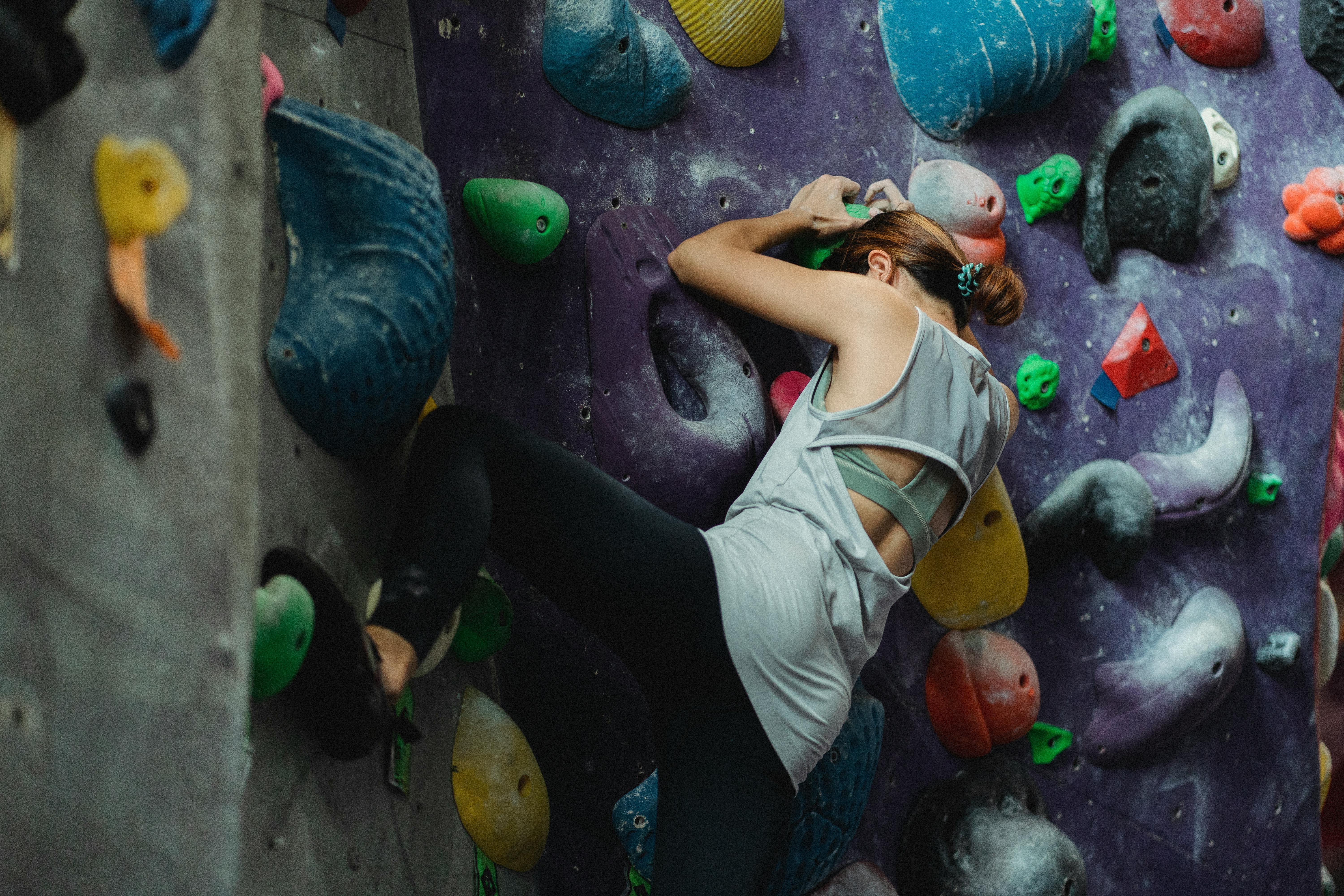 climber in activewear exercising on climbing wall