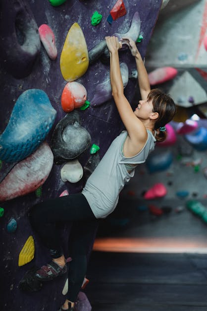 Premium Photo  Fitness, extreme sport and healthy lifestyle concept -  climber holds the rope. slender girl holds climbing equipment at a rock  wall. and looking at camera on background of rock