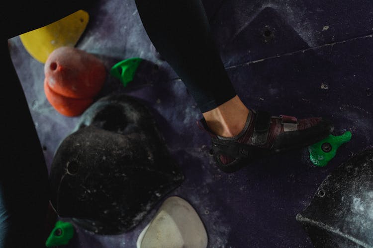 Strong Female Climber Climbing On Wall In Gym