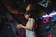 Focused ethnic climber treats hands with talcum powder