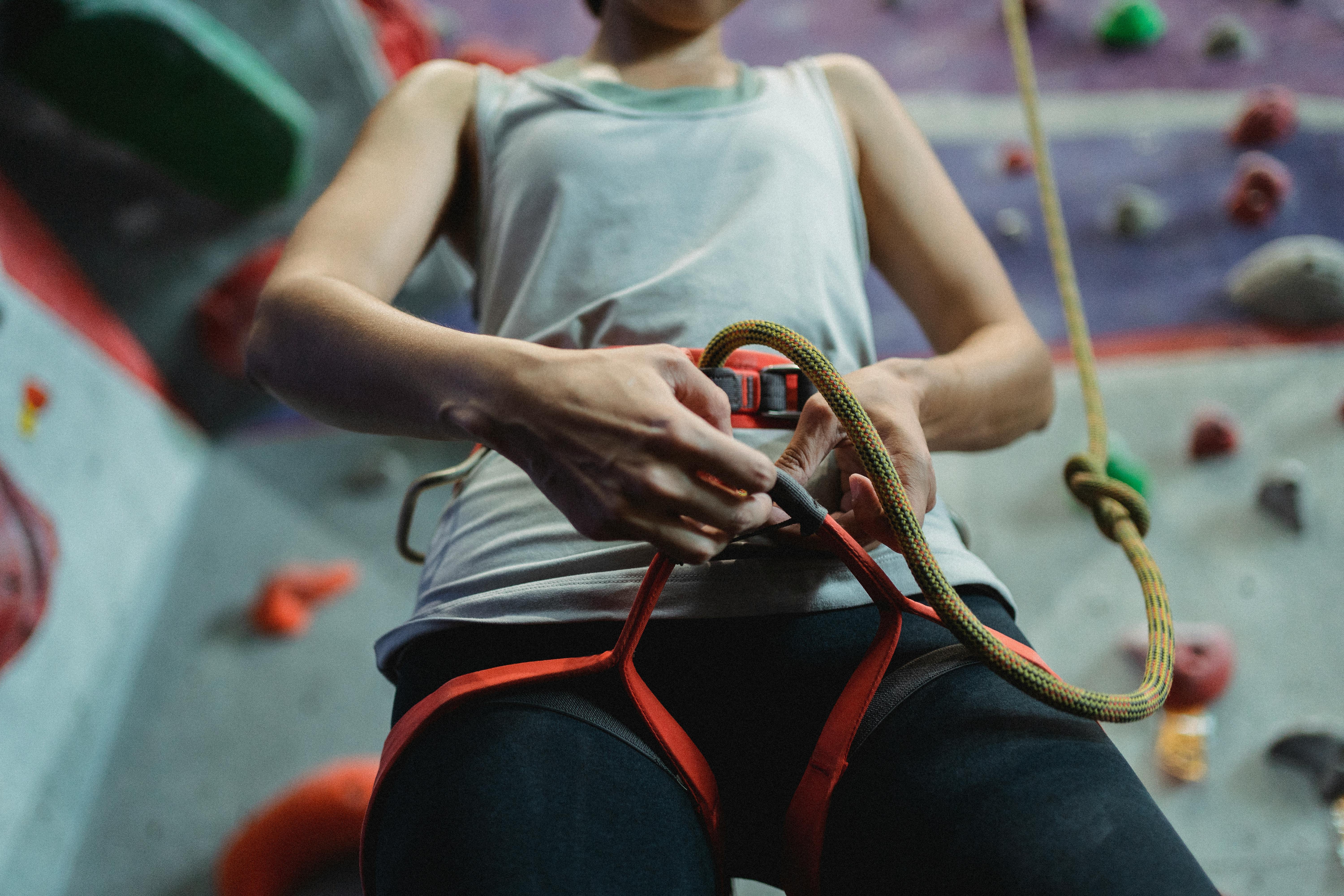 strong climber putting on belay against climbing wall