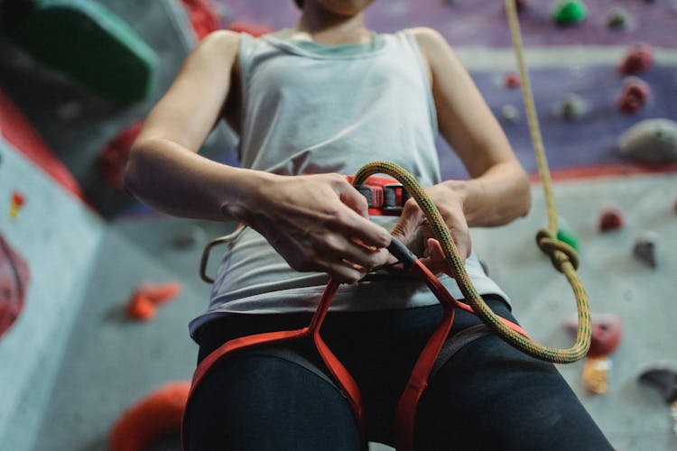 Strong Climber Putting On Belay Against Climbing Wall