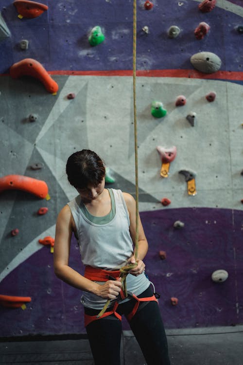 Free Woman preparing belay for ascending on wall Stock Photo