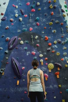 Woman preparing for climbing high on wall