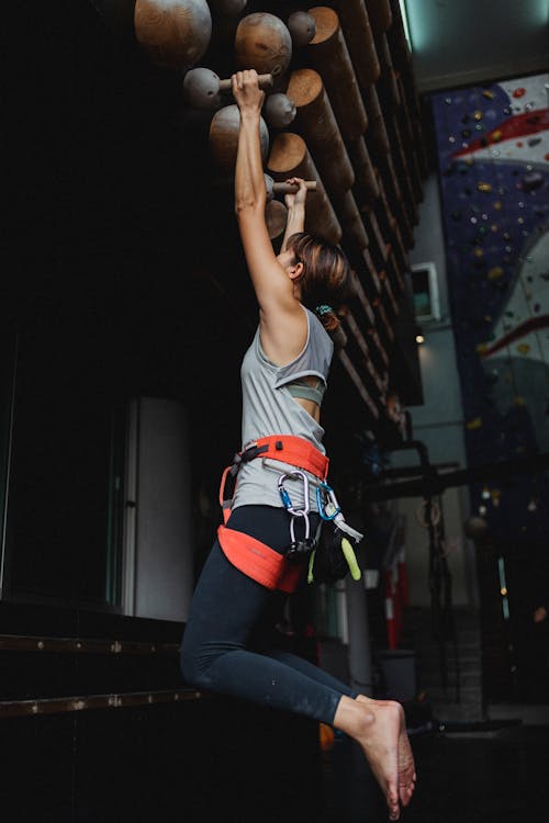 Free Faceless sportswoman doing hanging exercises in gym Stock Photo