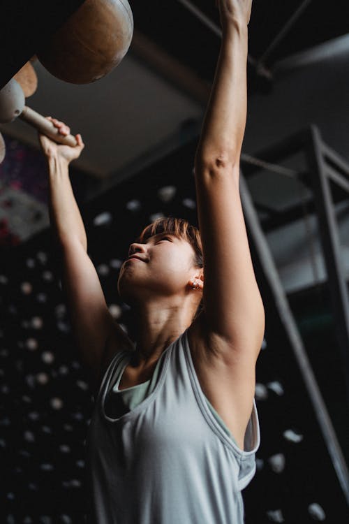 Bepaalde Vrouw Die Op Fitnessapparatuur Hangt