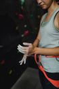 Crop fit female climber with safety belt before training