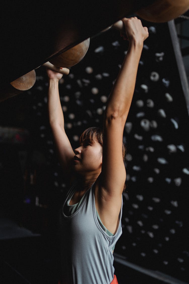 Fit Asian Mountaineer Grabbing Climbing Holds During Practice