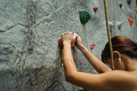 Unrecognizable strong mountaineer climbing rock during workout