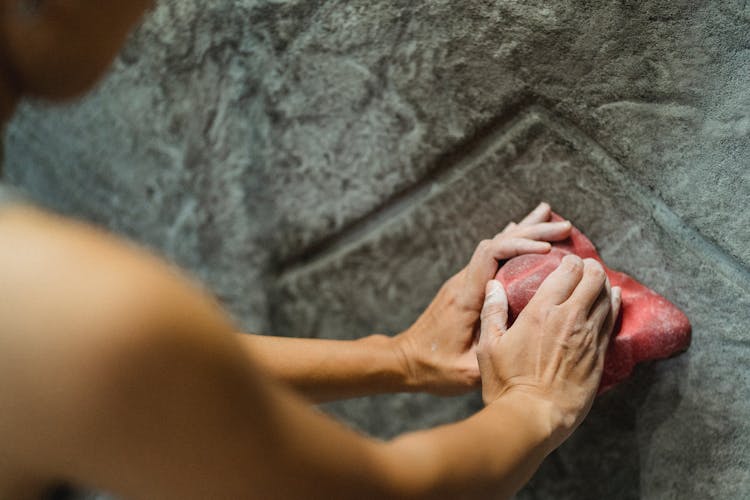 Woman Touching Climbing Hold On Stony Wall