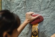 Woman touching climbing hold on rocky wall