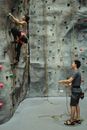Full body of strong climbers mountaineering climbing wall with help of each other