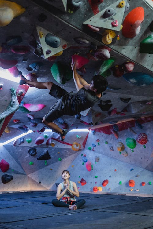 Chico Asiático Activo Colgado En El Techo De La Superficie De Escalada En El Gimnasio