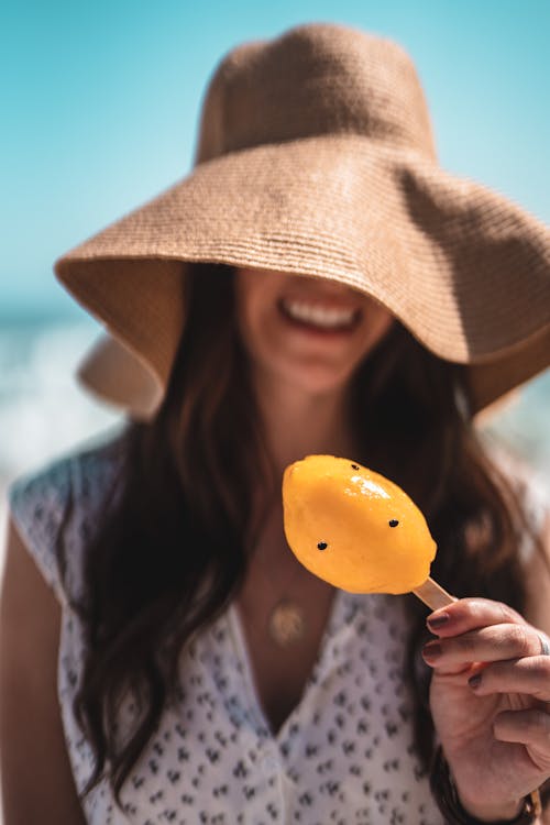 Free Shallow Focus Photo of Person Holding a Yellow Popsicle Stock Photo