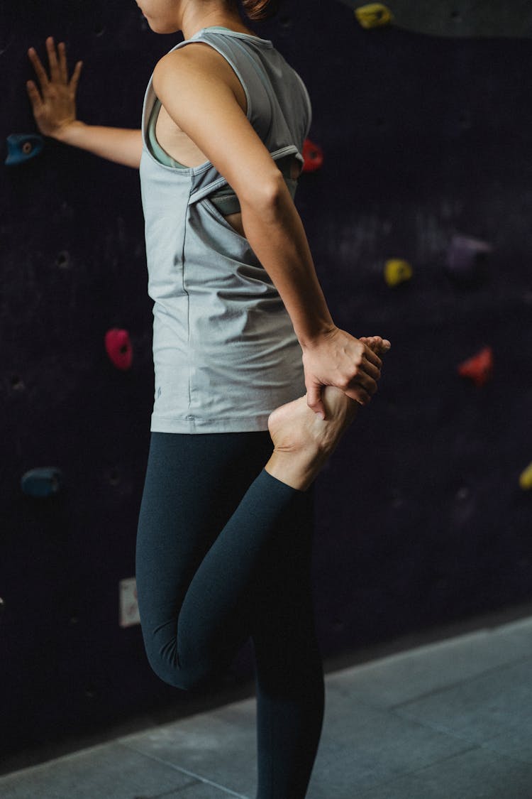 Strong Young Woman Stretching Leg Before Climbing Training