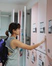 一名年轻女子穿着运动装，在现代健身设施中使用储物柜