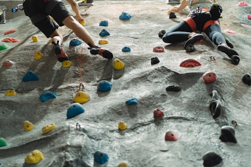 Free Anonymous climbers training on artificial wall in gym Stock Photo