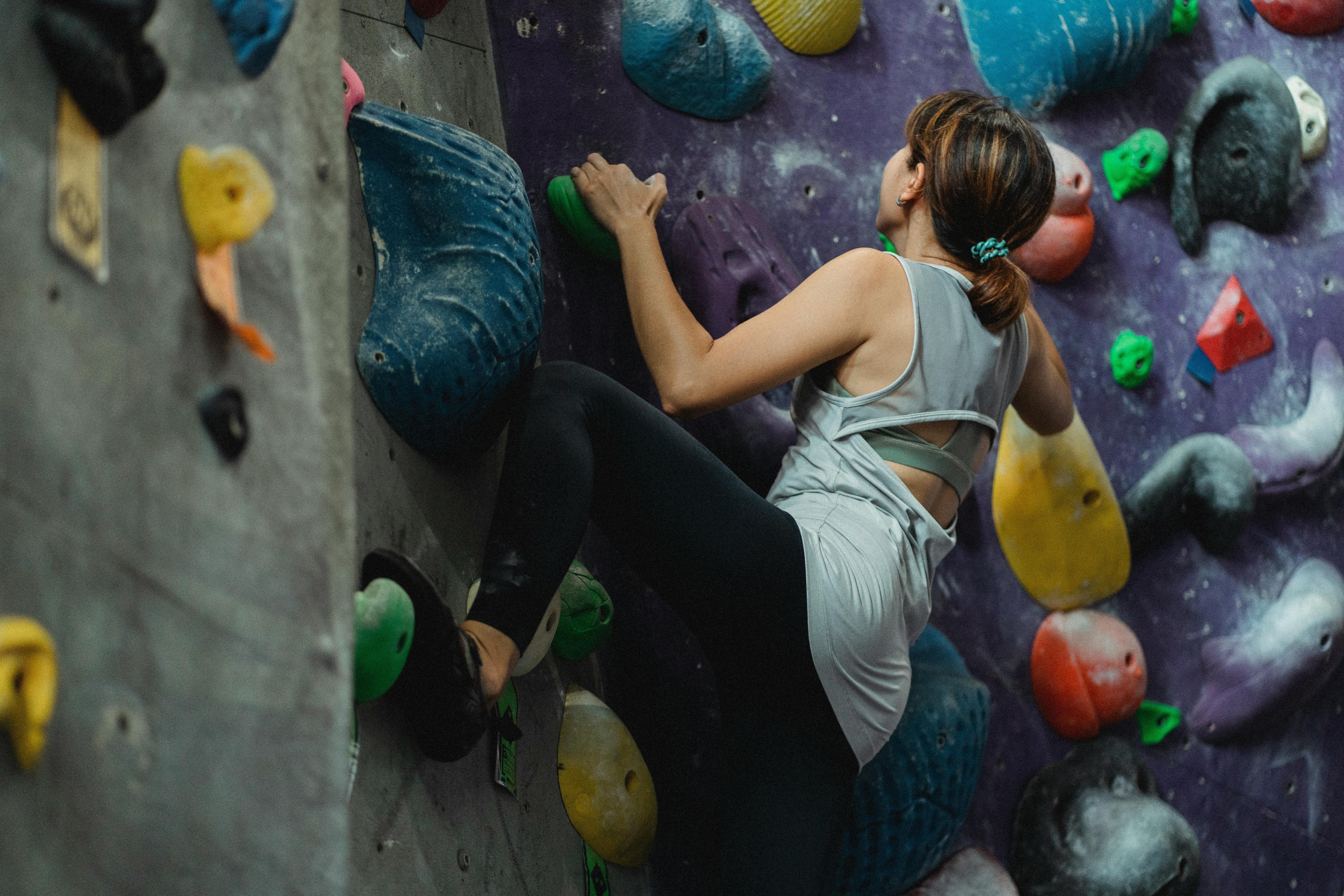 unrecognizable climber climbing wall during workout