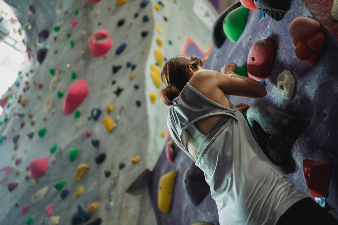 Anonymous woman hanging on climbing wall