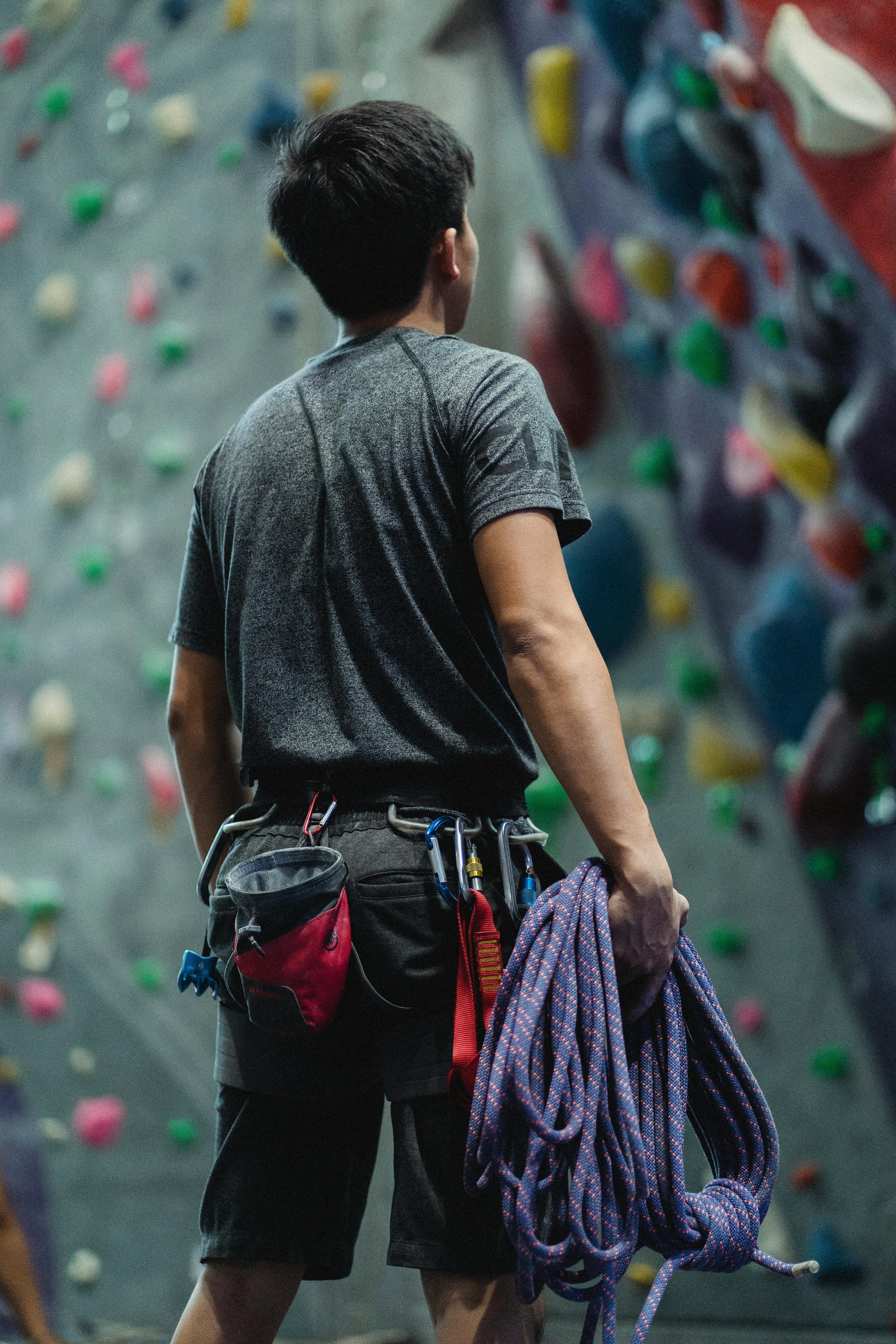 Unrecognizable male climber with safety rope near climbing wall · Free