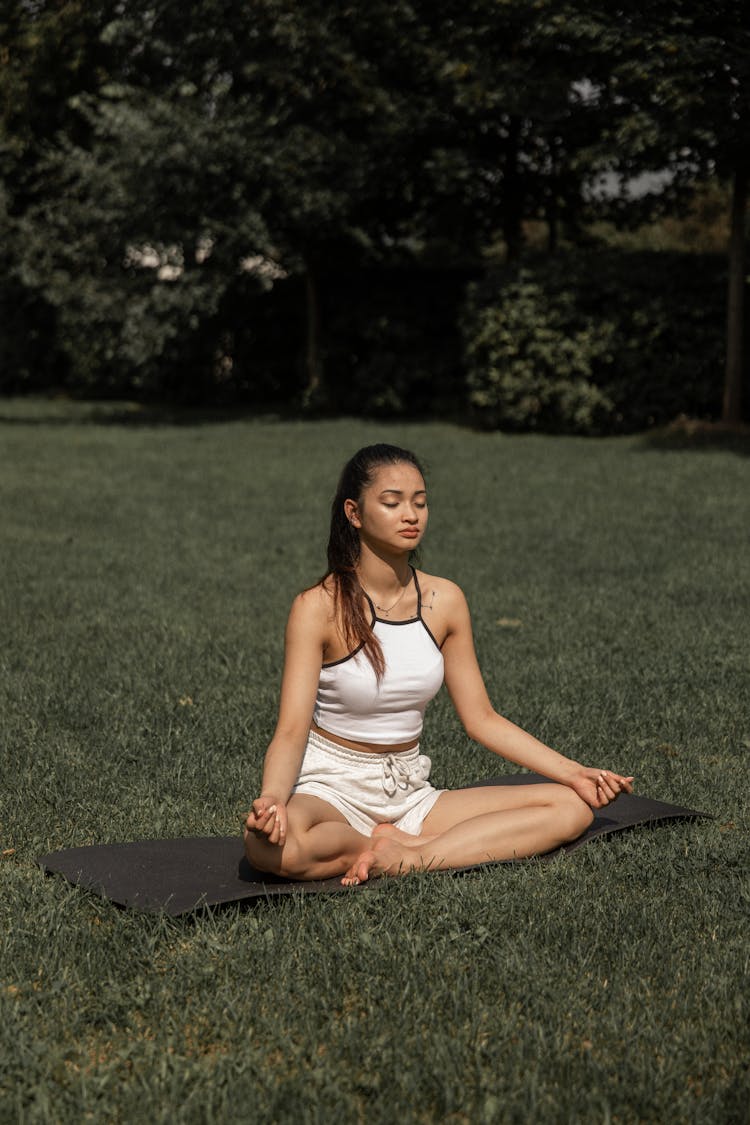 Relaxed Asian Woman Practicing Yoga On Mat