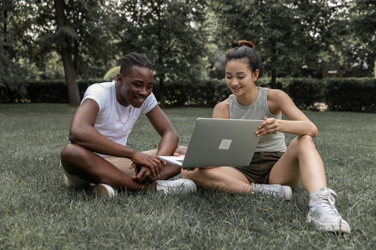 Cheerful Multiethnic Couple Watching Video On Laptop