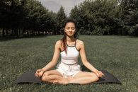 一位女士在宁静的公园里进行户外瑜伽冥想